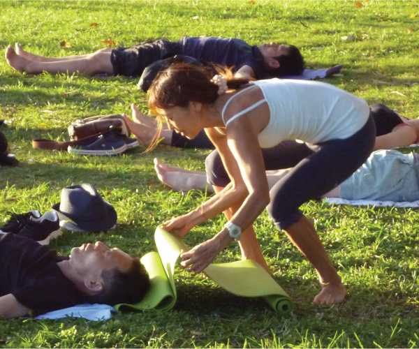 Masumi teaching yoga at Queen's Beach in Kapiolani Park, Honolulu
