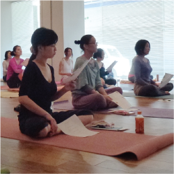 Students listening to Tedd Surman's yoga lecture at Lotus 8 Yoga studio in Tokyo, Japan